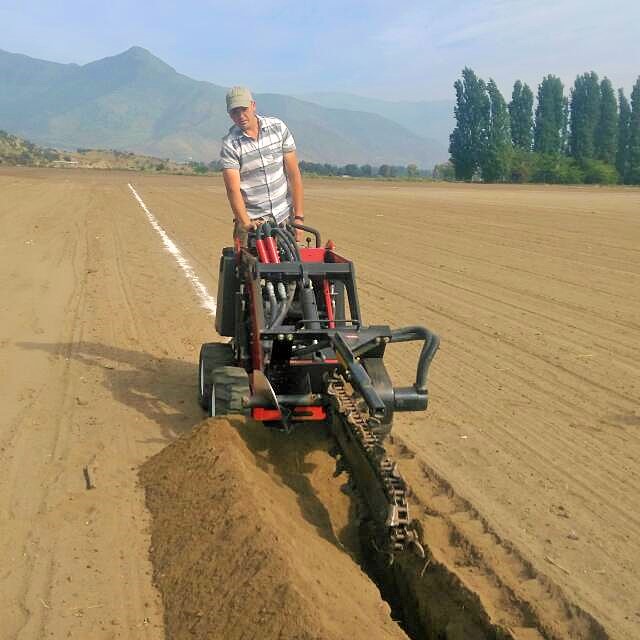 Operario de Mi Riego instalando riego con m&aacute;quina zanjadora